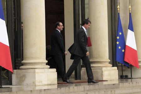 French President FrancoisHollande (L) watches as Prime Minister Manuel Valls leaves after their meeting at the Elysee Palace in Paris, August 25, 2014. REUTERS/John Schults