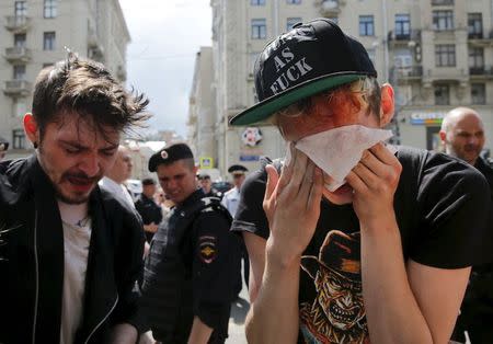 Gay rights activists react after being pepper sprayed by anti-gay protesters during an LGBT (lesbian, gay, bisexual, and transgender) community rally in central Moscow, Russia, May 30, 2015. REUTERS/Maxim Shemetov TEMPLATE OUT