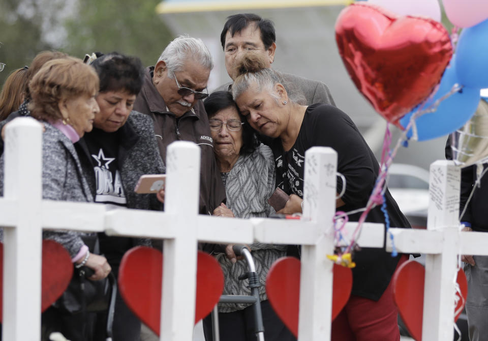 FILE - Family and friends gather around a makeshift memorial for the victims of the First Baptist Church shooting at Sutherland Springs Baptist Church, Nov. 10, 2017, in Sutherland Springs, Texas. The Justice Department said Wednesday, April 5, 2023, that it has tentatively settled a lawsuit over the 2017 mass shooting at a Texas church that will pay victims and their families more than $144 million. (AP Photo/Eric Gay, File)