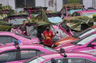 Workers from two taxi cooperatives assemble miniature gardens on the rooftops of unused taxis parked in Bangkok, Thailand, Thursday, Sept. 16, 2021. Taxi fleets in Thailand are giving new meaning to the term “rooftop garden,” as they utilize the roofs of cabs idled by the coronavirus crisis to serve as small vegetable plots and raise awareness about the plight of out of work drivers. (AP Photo/Sakchai Lalit)