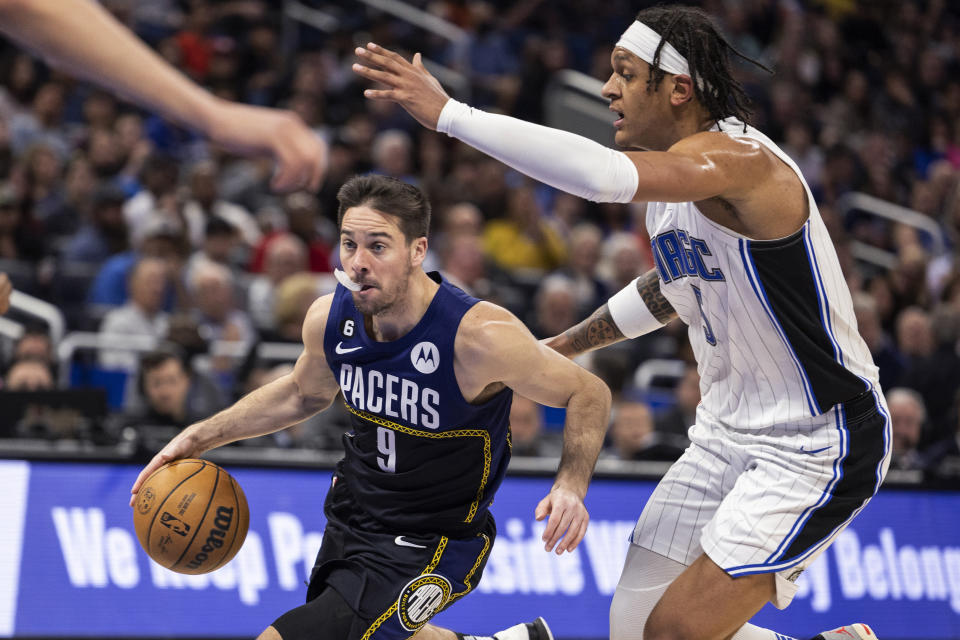 Indiana Pacers guard T.J. McConnell (9) drives against Orlando Magic forward Paolo Banchero (5) during the first half of an NBA basketball game Wednesday, Jan. 25, 2023, in Orlando, Fla. (AP Photo/Kevin Kolczynski)