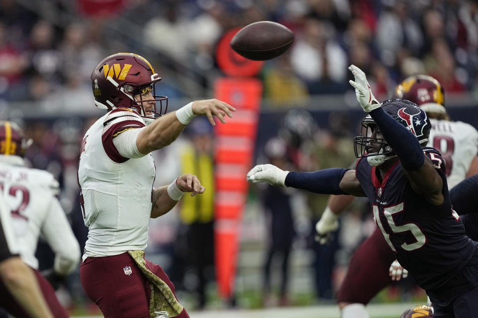 Washington Commanders quarterback Taylor Heinicke (4) throws past Houston Texans linebacker Ogbonnia Okoronkwo (45) during the second half of an NFL football game Sunday, Nov. 20, 2022, in Houston. (AP Photo/David J. Phillip)