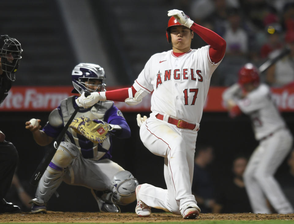 Colorado Rockies catcher Elias Diaz throws the ball back to the pitcher after Los Angeles Angels' Shohei Ohtani swung at a pitch during the fourth inning of a baseball game against Wednesday, July 28, 2021, in Anaheim, Calif. (AP Photo/John McCoy)