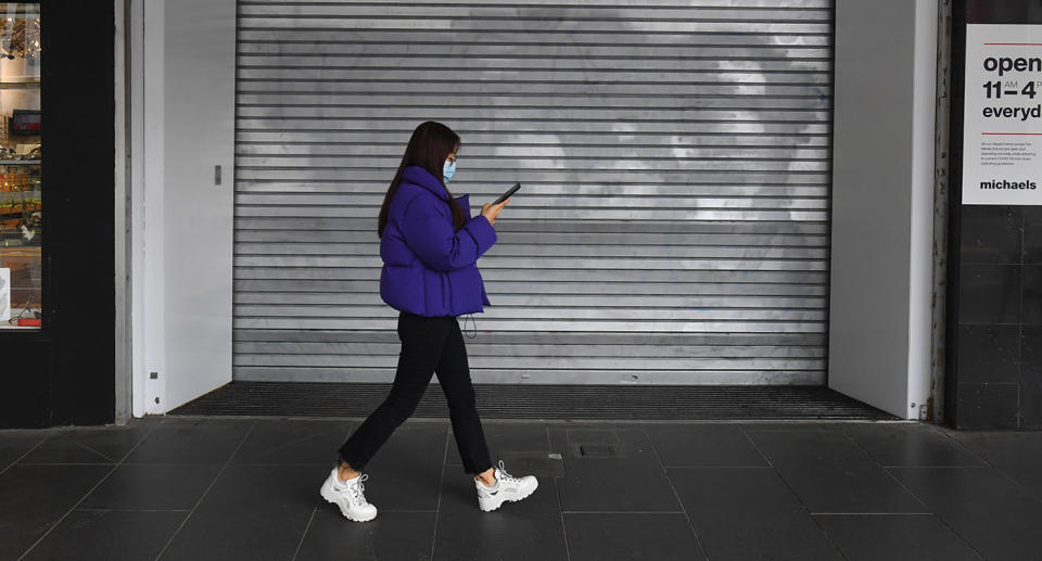 A pedestrian walks past a closed retail store in Melbourne, Thursday, July 23, 2020. 