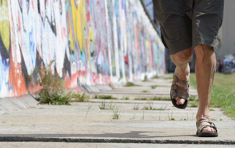 Marathon runner Sigrid Eichner runs along the old Berlin Wall on August 11, 2014, before the start of the third "100MeilenBerlin" marathon event