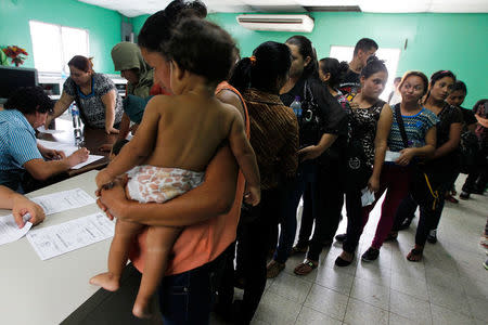 FILE PHOTO: Women and their children wait in line to register at the Honduran Center for Returned Migrants after being deported from Mexico, in San Pedro Sula, northern Honduras June 20, 2014. Thousands of young people are hoping to reach the U.S. from their impoverished and violent homes in Central America. In the eight months ended June 15, the U.S. has detained about 52,000 children at the Mexican border, double the figure the year earlier. Picture taken June 20, 2014. REUTERS/Jorge Cabrera/File Photo