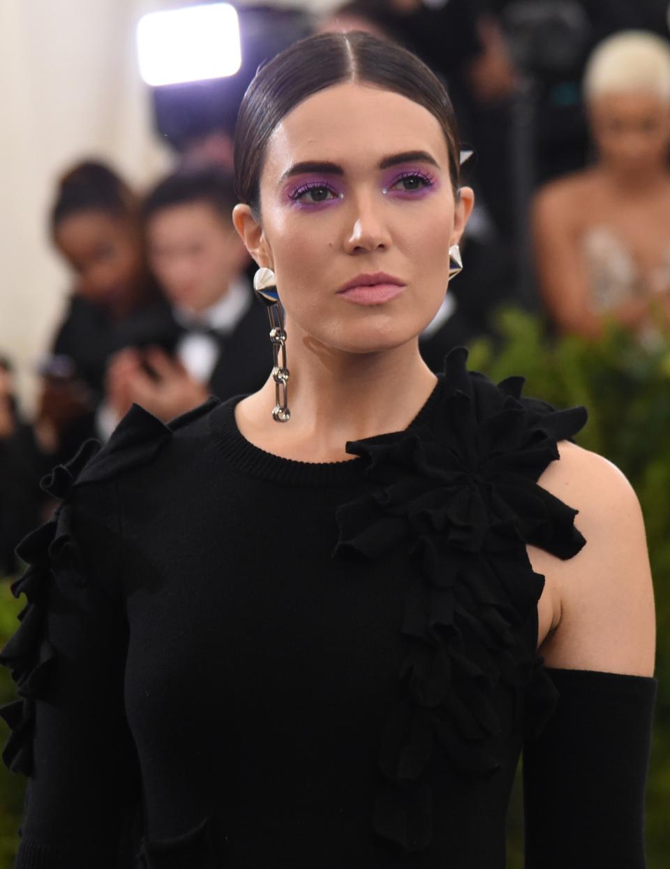 <p>Moore’s lilac-washed lids, bold brows, matte lips, and slicked-back hair is nothing like we’ve seen her wear before, but we absolutely love it! (Photo: Getty Images) </p>