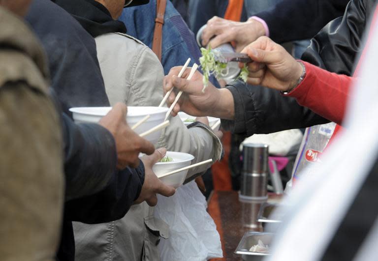 File photo of poor and homeless people receiving charity soup noodles at a park in central Tokyo