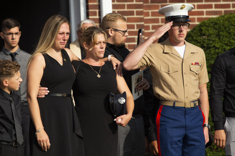 Kiersten Haub, from left, Erika Starke, and Michael Haub, family members of New York firefighter Michael Haub, attend a second funeral service for him in Franklin Square, N.Y., Tuesday, Sept. 10, 2019. The firefighter from New York's Long Island who died in the World Trade Center attacks is being remembered for a second time on the eve of the 18th anniversary of 9/11. Friends and family gathered at the memorial service for Haub on Tuesday in Franklin Square. Last week, the New York City medical examiner identified more of his remains recovered at ground zero. (AP Photo/Eduardo Munoz Alvarez)