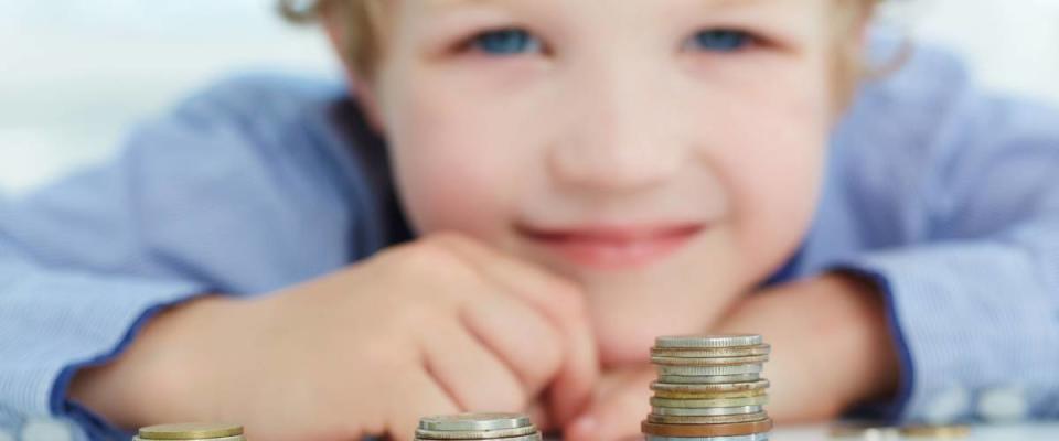 Young boy build a tower by coins. The concept of children's economic education.