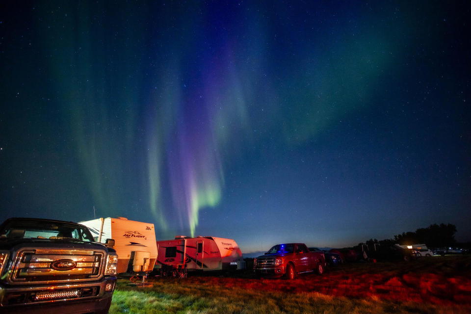 Evacuees from Yellowknife, territorial capital of the Northwest Territories, are greeted with the Aurora Borealis as they arrive to a free campsite provided by the community in High Level, Alta., Friday, Aug. 18, 2023. (Jason Franson /The Canadian Press via AP)