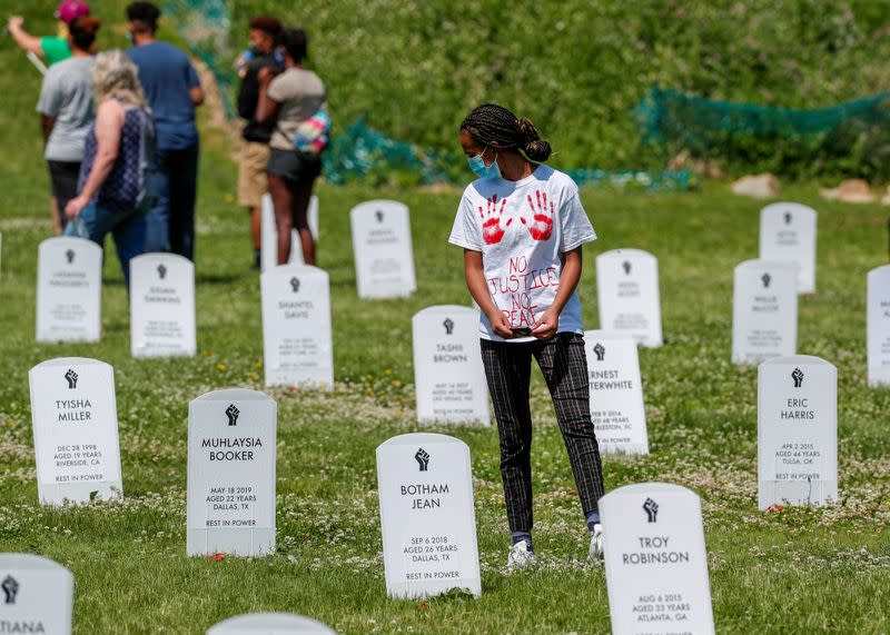 Visitors walk among headstone memorial of people killed by police near Floyd arrest site in Minneapolis