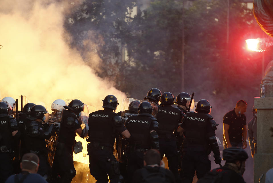 Serbian riot police clashes with protesters in Belgrade, Serbia, Wednesday, July 8, 2020. Serbia's president Aleksandar Vucic backtracked Wednesday on his plans to reinstate a coronavirus lockdown in Belgrade after thousands protested the move and violently clashed with the police in the capital. (AP Photo/Darko Vojinovic)