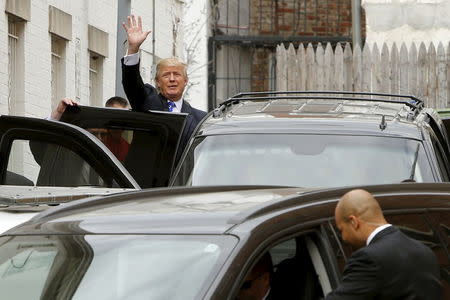 Donald Trump waves to onlookers and reporters as he departs through a back door after meetings at Republican National Committee headquarters in Washington. REUTERS/Jonathan Ernst