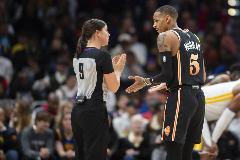 Atlanta Hawks guard Dejounte Murray, right, speaks with referee Natalie Sago during the second half of an NBA basketball game against the Golden State Warriors, Friday, March 17, 2023, in Atlanta. (AP Photo/Hakim Wright Sr.)