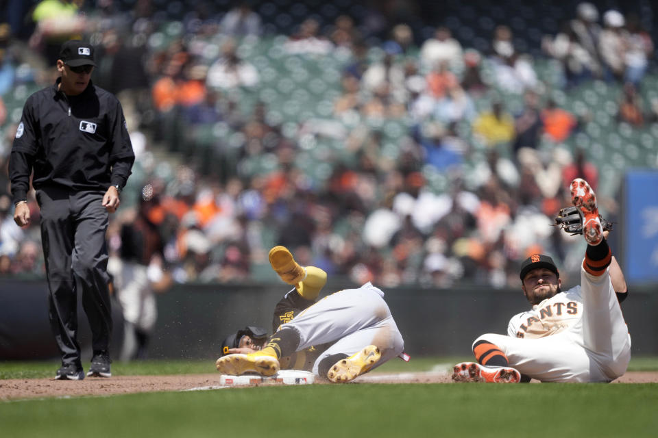 Pittsburgh Pirates' Rodolfo Castro, center, is tagged out trying to steal third base by San Francisco Giants third baseman J.D. Davis (7) during the fifth inning of a baseball game in San Francisco, Wednesday, May 31, 2023. (AP Photo/Tony Avelar)