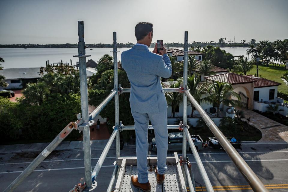 Scott Diament uses his cellphone on the rooftop of his new home that is under construction in the Northwood Shores neighborhood in West Palm Beach, Fla., on July 24, 2023.