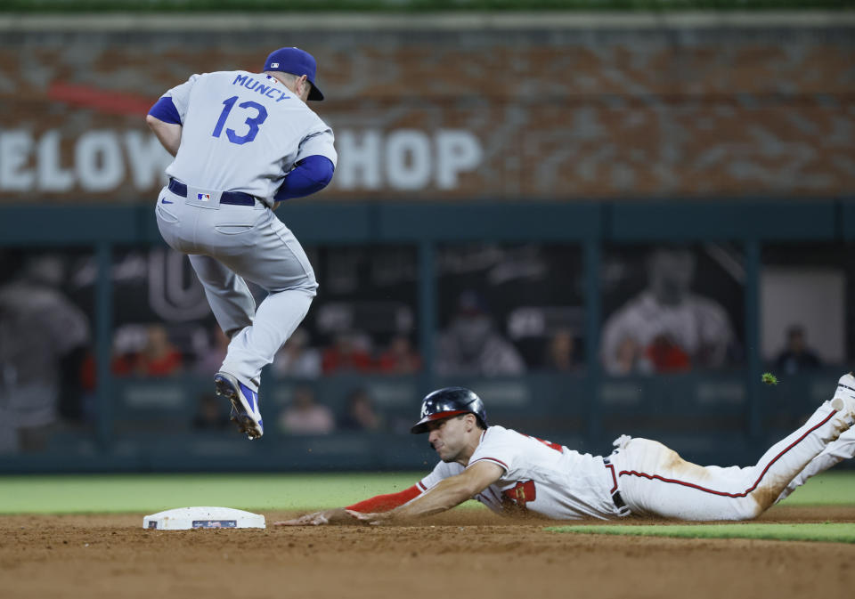 Atlanta Braves' Matt Olson is safe at second, sliding in under Los Angeles Dodgers' Max Muncy during the tenth inning of a baseball game won by the Los Angeles Dodgers 5-3 on Sunday, June 26, 2022, in Atlanta. (AP Photo/Bob Andres)