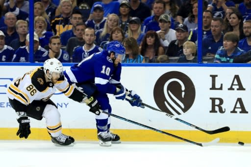 J.T. Miller (R) of the Tampa Bay Lightning and Kevan Miller of the Boston Bruins fight for the puck