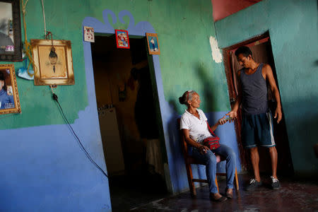 Zulay Pulgar (C), 43, gives Venezuelan bolivar notes to her husband Maikel Cuauro, 30, in their house in Punto Fijo, Venezuela November 17, 2016. Picture taken November 17, 2016. REUTERS/Carlos Garcia Rawlins