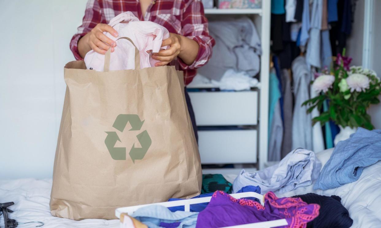 <span>A woman selecting clothes from her wardrobe for recycling or donating to a charity shop.</span><span>Photograph: Oksana Krasiuk/Alamy</span>