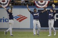 Milwaukee Brewers' Ryan Braun, Lorenzo Cain and Christian Yelich celebrate after Game 3 of the National League Championship Series baseball game against the Los Angeles Dodgers Monday, Oct. 15, 2018, in Los Angeles. The Brewers won 4-0 to take a 2-1 lead in the series. (AP Photo/Jae Hong)