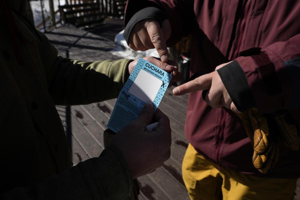 A skier holds a lift ticket at Parker-Fitzgerald Cuchara Mountain Park on Sunday, March 19, 2023, near Cuchara, Colo. Some communities including Cuchara are now finding a niche, offering an alternative to endless lift lines and sky-high ticket prices. They're reopening, several as nonprofits, offering a mom-and-pop experience at a far lower cost than mountains run by corporate conglomerates. (AP Photo/Brittany Peterson)