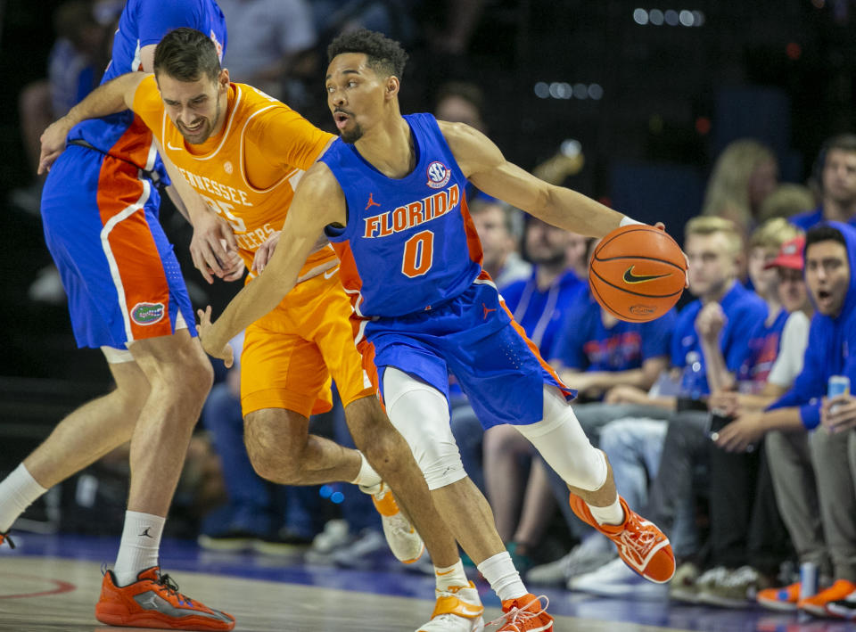 Tennessee guard Santiago Vescovi, center, tries to get through Florida forward Colin Castleton, left, and Florida guard Myreon Jones (0) during the first half of an NCAA college basketball game, Wednesday, Feb. 1, 2023, in Gainesville, Fla. (AP Photo/Alan Youngblood)