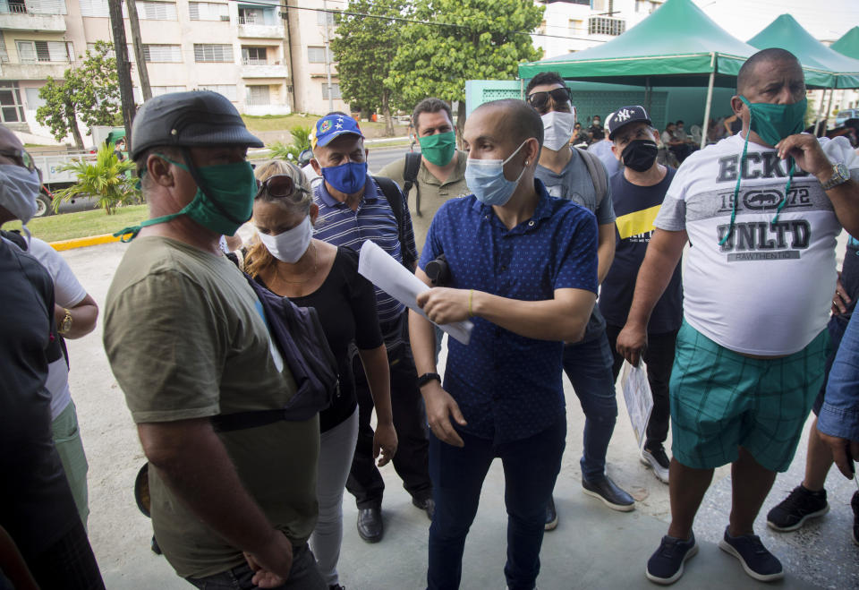 Shoppers organize themselves as they wait to enter Mercabal wholesale market in Havana, Cuba, Friday, July 31, 2020. The government is letting private businesses buy wholesale for the first time. (AP Photo/Ismael Francisco)