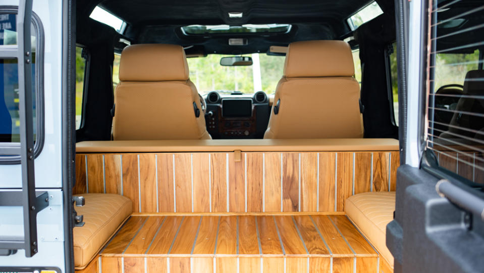 The teak rear flooring and storage bench inside E.C.D. Automotive Design's Project Britton, an all-electric Defender 110 restomod.