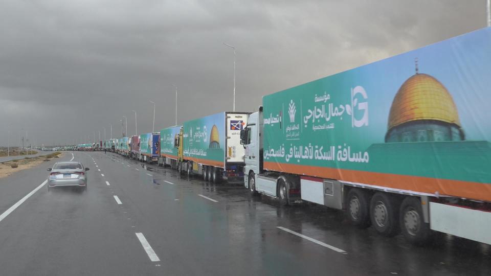 Trucks loaded with humanitarian aid supplies wait along the road leading to the Rafah border crossing with Gaza, in Rafah, northeast Egypt, in November 2023. / Credit: CBS News