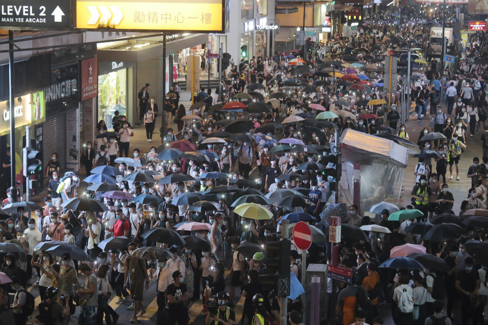 Pro-democracy demonstrators march holding their phones with flashlights on during a protest to mark the first anniversary of a mass rally against the now-withdrawn extradition bill in Hong Kong, Tuesday, June 9, 2020. One year ago, a sea of humanity a million people by some estimates marched through central Hong Kong on a steamy afternoon. It was the start of what would grow into the longest-lasting and most violent anti-government movement the city has seen since its return to China in 1997. (AP Photo/Kin Cheung)