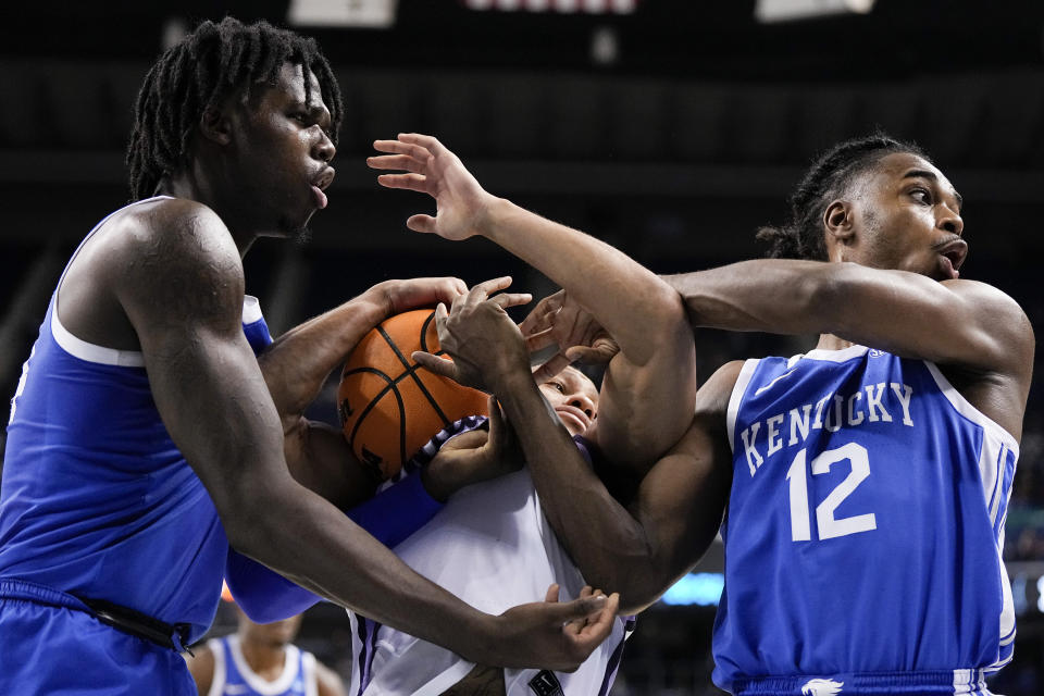 Kansas State guard Markquis Nowell, middle, battles for the ball between Kentucky forward Chris Livingston, left, and guard Antonio Reeves during the second half of a second-round college basketball game in the NCAA Tournament on Sunday, March 19, 2023, in Greensboro, N.C. (AP Photo/Chris Carlson)