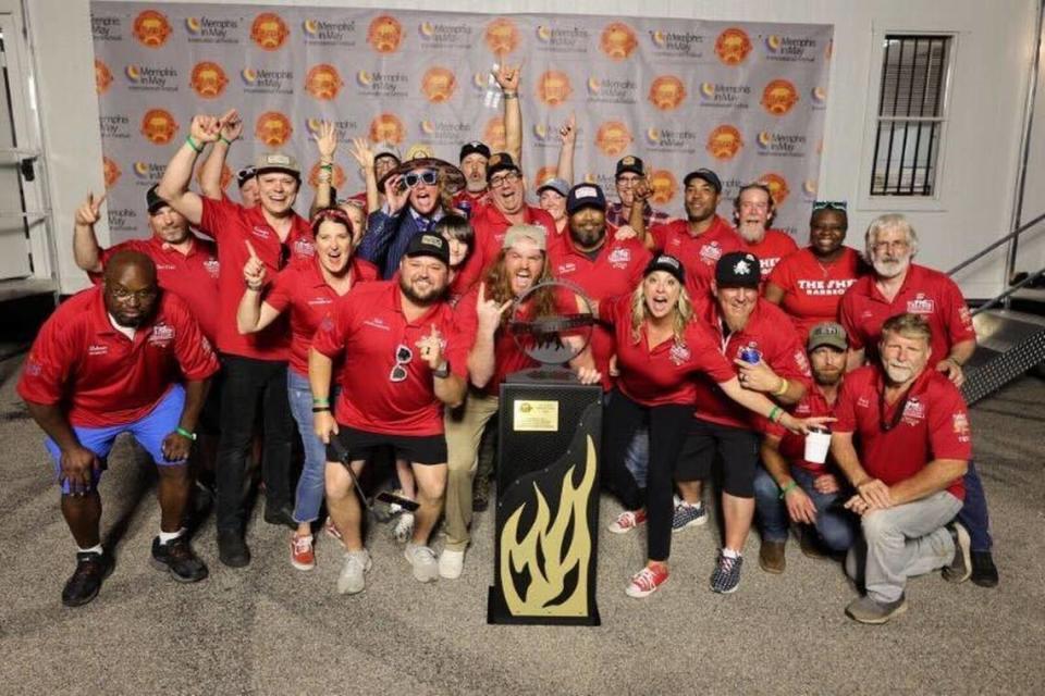 The Shed’s barbecue team stands behind a newly acquired trophy from Memphis in May 2024.