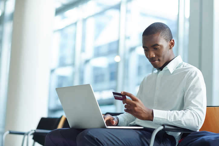 Shot of a businessman sitting in an airport making an online reservation with his credit card