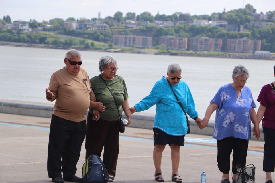 Community members held hands in the Quebec City port, where C.D. Howe, a medical ship, transported several Inuit for tuberculosis treatment.