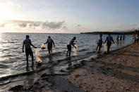 Policemen collect trash in the waters off the beach at the holiday island of Boracay during the first day of a temporary closure for tourists, in Philippines April 26, 2018. REUTERS/Erik De Castro