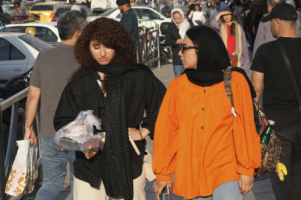 A woman walks around Tajrish commercial district without wearing her mandatory Islamic headscarf in northern Tehran, Iran, Saturday, April 29, 2023. More women are choosing not to wear the mandatory headscarf, or the hijab, publicly in Iran. Such open defiance of the law follows months of protests over the September death of 22-year-old Mahsa Amini while in the custody of the country's morality police, for wearing her hijab too loosely. (AP Photo/Vahid Salemi)