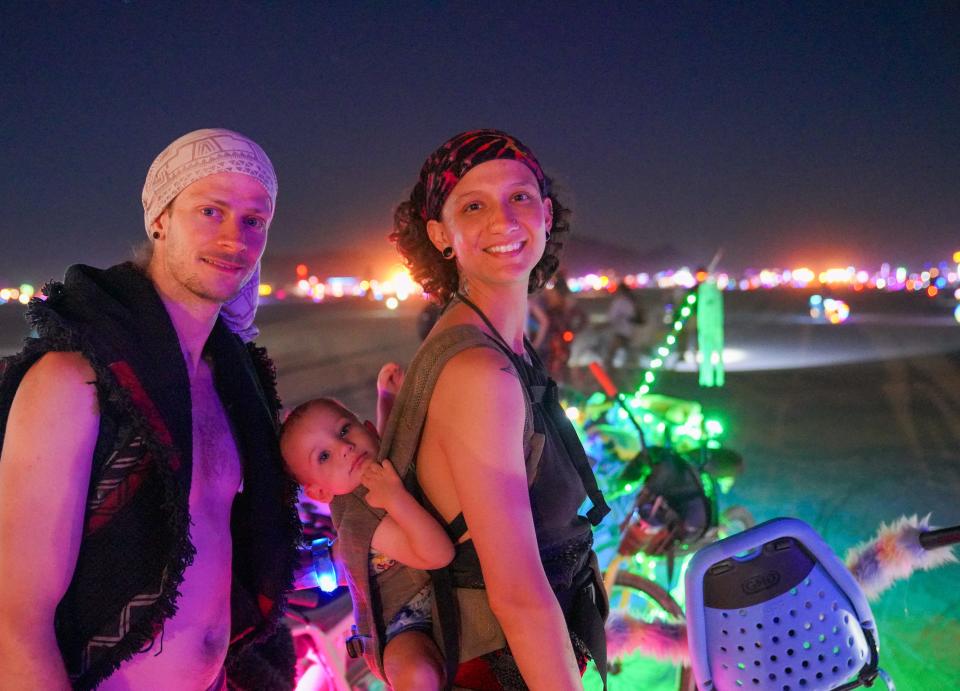 Sarah and Ethan Matthews of Reno pose for a photo with their 1 year-old son, Oaken, at Burning Man.