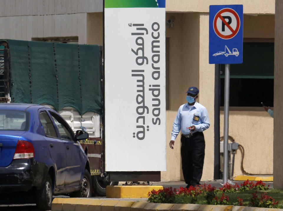 A security person wears a mask as he checks vehicles entering a compound for Saudi Aramco in Jiddah, Saudi Arabia, Monday, March 9, 2020. State oil giant Saudi Aramco sees shares drop by 10% as Riyadh stock market opens, halting trading. (AP Photo/Amr Nabil)