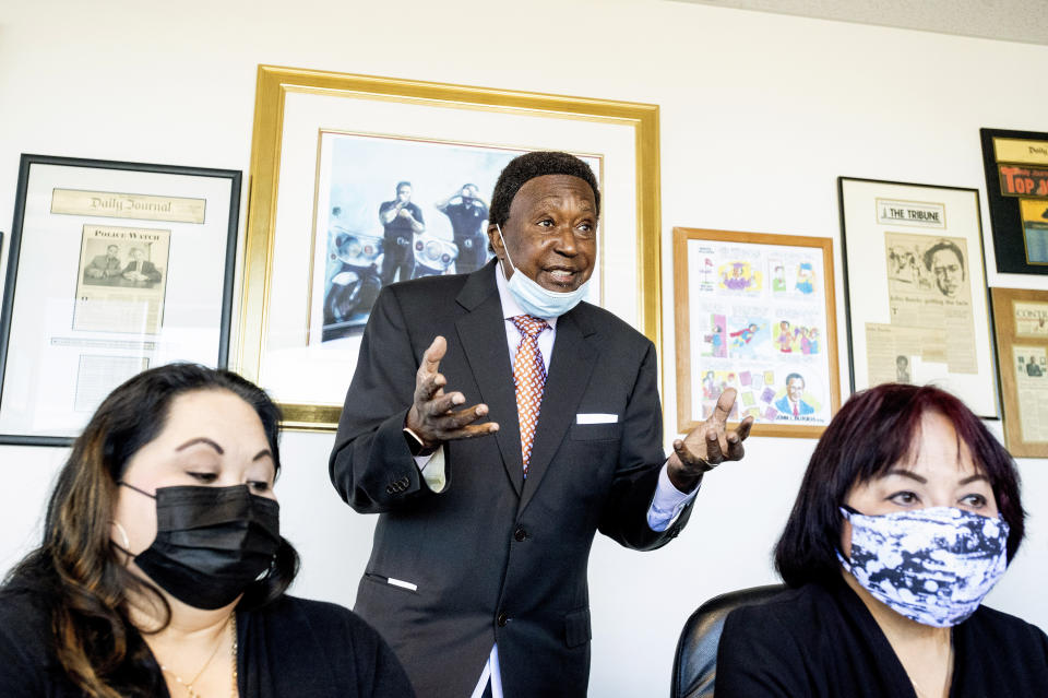 Attorney John Burris discusses the police shooting of Laudemer Arboleda while speaking in his offices on Monday, May 3, 2021, in Oakland, Calif. Seated are Arboleda's mother Jeannie Atienza, right, and sister Jennifer Leong. Danville police officer Andrew Hall faces felony charges for killing Arboleda during a 2018 car chase. (AP Photo/Noah Berger)