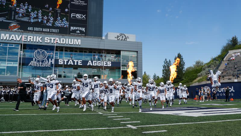 The Utah Aggies storm the field before playing the UConn Huskies at the Maverik Stadium in Logan on Saturday, Aug. 27, 2022.