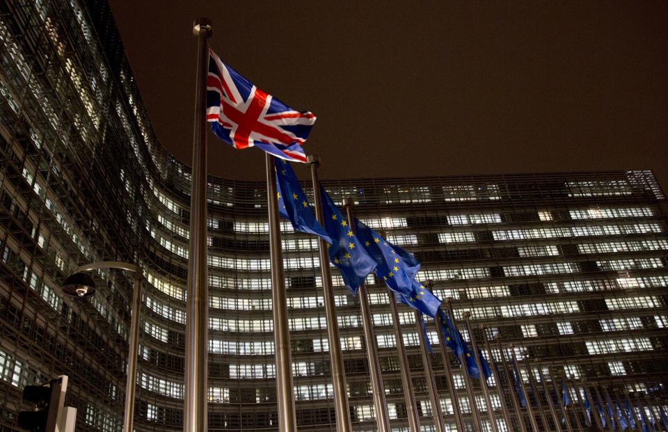 A Union flag, left, flaps in the wind alongside EU flags in front of European Commission headquarters in Brussels, Wednesday, Nov. 21, 2018. British Prime Minister Theresa May meets with European Commission President Jean-Claude Juncker on Wednesday evening in a bid to finalize a Brexit agreement as she continues to battle domestic critics of the draft deal. (AP Photo/Virginia Mayo)