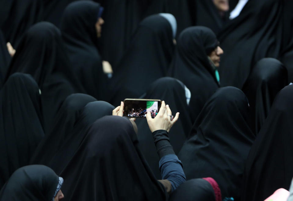 An Iranian woman takes a picture during a rally in support of wearing headscarves at the Shahid Shiroudi Stadium in Tehran, on July 11, 2019. Under Islamic law, since the 1979 revolution, hijab (which requires females to cover their hair and much of their body in loose clothing to prevent their figures being seen) is obligatory for local and foreign women in the country. (Credit: / AFP via Getty Images)