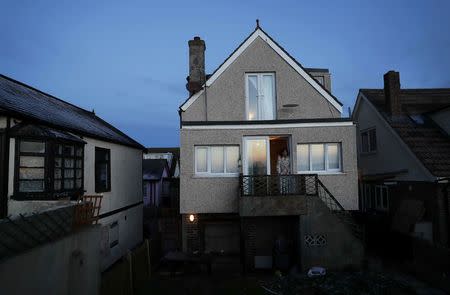 A resident looks out from her home in the village of Jaywick which is threatened by a storm surge, in Essex, Britain January 13, 2017. REUTERS/Stefan Wermuth