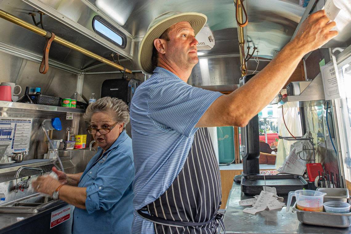 Hostess María Teresa Larios washes dishes as founder and owner Royd Lemus reads order tickets at Royd’s.