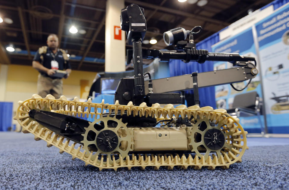 Steven Roberson, of QinetiQ, demonstrates a unmanned robotic system at the 8th annual Border Security Expo, Tuesday, March 18, 2014, in Phoenix. The two day event features panel discussions, sharing intelligence, and exhibitors displaying high-tech wares aimed at securing lucrative government contracts and private sales. (AP Photo/Matt York)