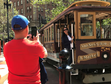 Tourists take pictures of an immobile cable car during a power cut in downtown San Francisco, California, U.S. April 21, 2017. REUTERS/Alexandria Sage