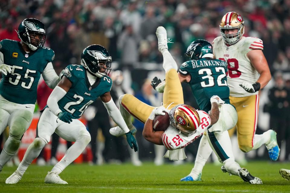 San Francisco 49ers running back Elijah Mitchell (25) is upended by Philadelphia Eagles safety Reed Blankenship (32) during the second half of an NFL football game, Sunday, Dec. 3, 2023, in Philadelphia. (AP Photo/Matt Slocum)