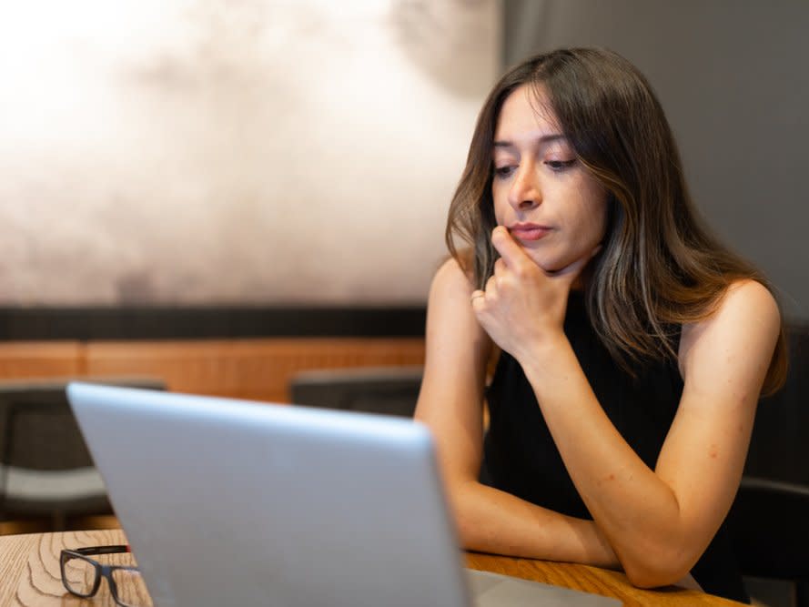 Frau arbeitet am Laptop und ist nachdenklich